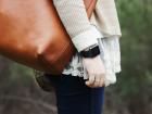 Mujer de perfil con un bolso de piel y un reloj inteligente en su muñeca