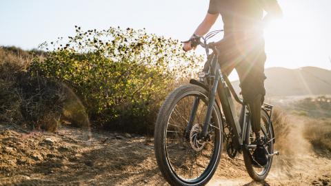 Hombre subido a una bicicleta electrica subiendo una colina